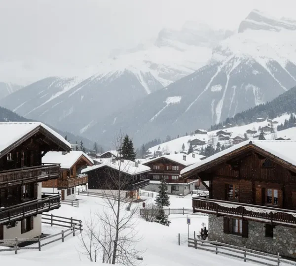 Vue panoramique de Crans-Montana avec chalets traditionnels et sommets enneigés du Valais